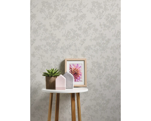 Scène avec papier peint à motifs, table avec décoration et cadre photo