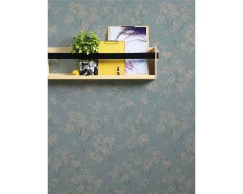 Wand mit floral gemusterter Tapete und Regal mit Dekoration