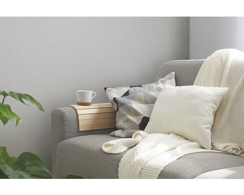 Canapé gris avec coussins, jeté et plateau d''accoudoir dans le salon.