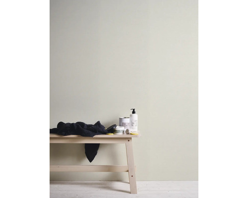 Wandgestaltung mit Farbe, Handtuch und Pflegeprodukten auf einem Holztisch