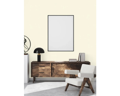 Wohnzimmer mit Kommode, Lampe, Sessel und gerahmtem Poster