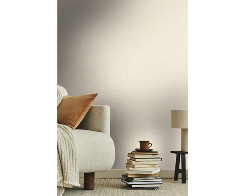 Salon avec canapé, pile de livres et papier peint texturé