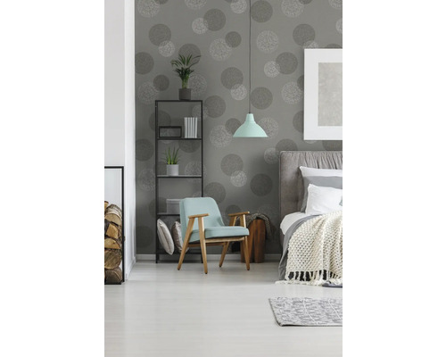 Chambre à coucher avec lit, fauteuil, étagère et papier peint à motifs circulaires