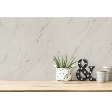 Papier peint décoratif avec motif marbré sur le mur avec plante en pot et éléments décoratifs sur une table en bois
