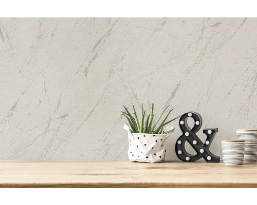 Papier peint décoratif avec motif marbré sur le mur avec plante en pot et éléments décoratifs sur une table en bois