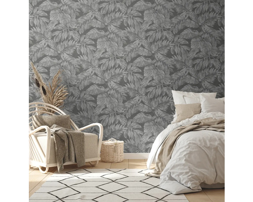 Schlafzimmer mit Blättertapete, Bett, Sessel und Teppich