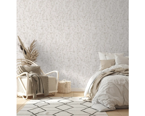Chambre à coucher claire avec papier peint à motifs floraux, fauteuil et lit