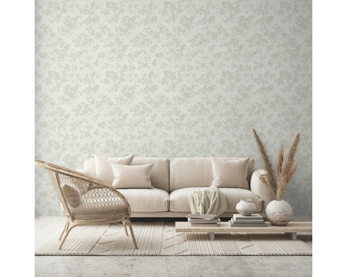 Salon avec canapé, fauteuil, table et papier peint à motifs floraux.