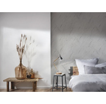 Chambre lumineuse avec papier peint à motifs, lit en bois et éléments décoratifs sur une table en bois