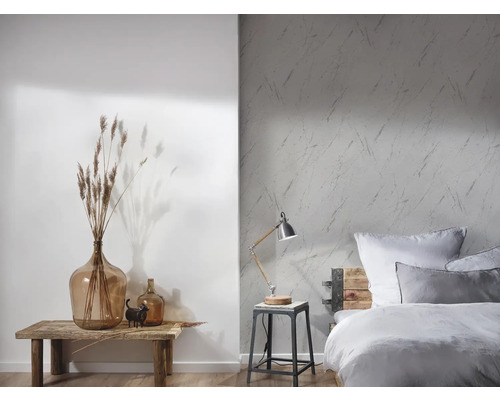 Chambre lumineuse avec papier peint à motifs, lit en bois et éléments décoratifs sur une table en bois