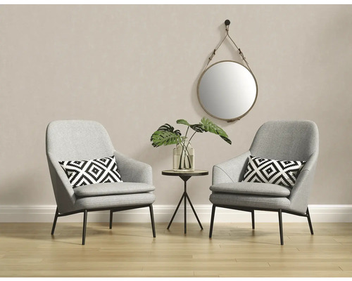 Scène de pièce lumineuse et conviviale avec deux fauteuils gris, une petite table et un miroir rond