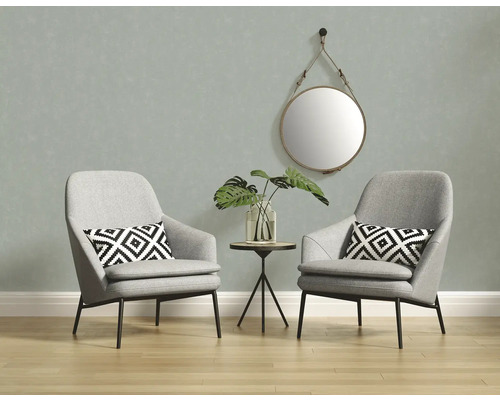 Deux fauteuils gris avec un miroir rond et une table d''appoint dans une pièce lumineuse.