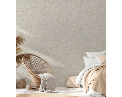 Heller Raum mit Rattansessel, Bett und gemusterter Tapete für ein harmonisches Ambiente.