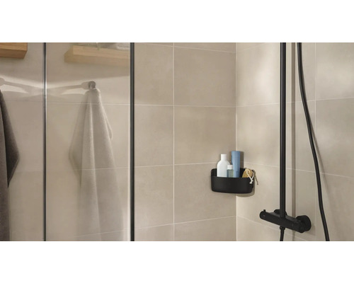 Salle de bains lumineuse avec douche, panier de rangement et serviettes