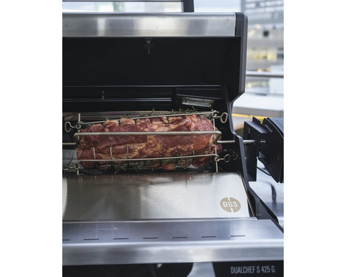 Fleisch am Drehspiess auf einem Grill zubereitet