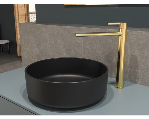 Vasque noire avec robinet doré sur une étagère