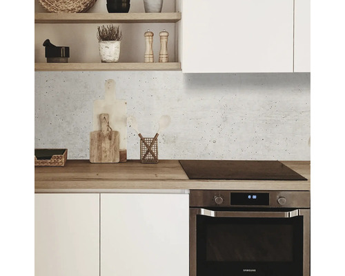 Scène de cuisine avec armoires blanches, plan de travail en bois et panneau mural imitation béton