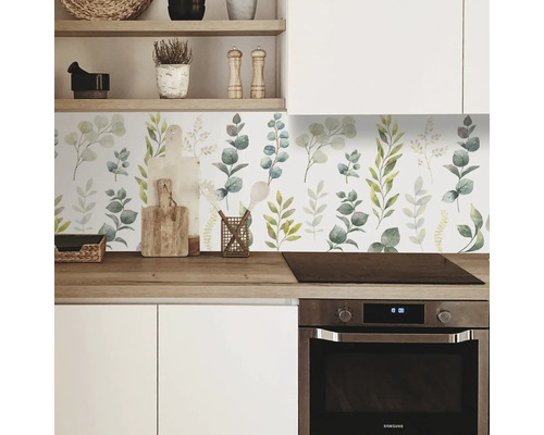 Crédence de cuisine avec décor de feuilles botaniques derrière le plan de travail et la cuisinière