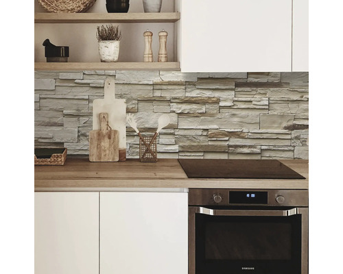 Scène de cuisine avec des panneaux muraux en pierre et des ustensiles de cuisine sur le plan de travail.