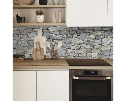 Scène de cuisine avec panneau mural en pierre, armoires blanches et plan de travail en bois