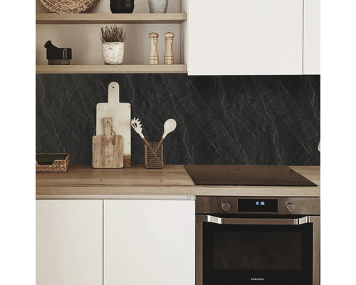 Cuisine moderne avec fond noir, plan de travail en bois et armoires blanches.