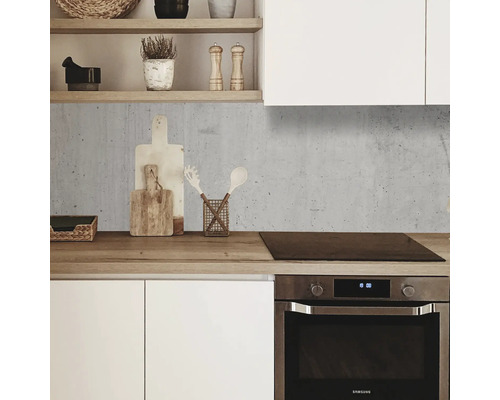 Crédence de cuisine aspect béton dans une cuisine moderne avec des armoires blanches et un plan de travail en bois.