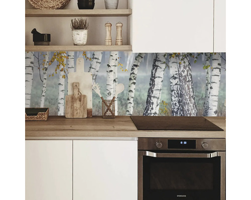 Scène de cuisine avec cuisine intégrée blanche, plan de travail en bois et crédence avec motif de forêt de bouleaux