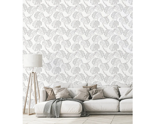 Salon avec canapé et papier peint mural à motif de feuilles de Monstera