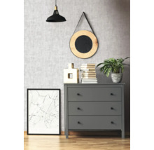 Graue Kommode mit drei Schubladen in einem Zimmer mit dekorativen Elementen wie einer Lampe, einem Spiegel und einem gerahmten Bild.