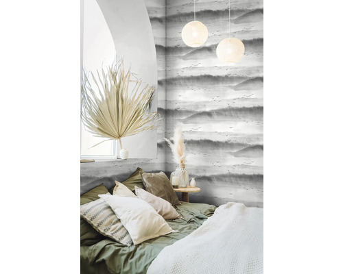 Chambre lumineuse avec papier peint à motifs, lit et éléments décoratifs