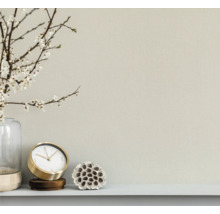 Nahaufnahme einer Wand mit Uhr, Dekoration und Vase mit Blumen