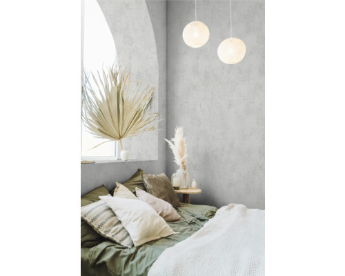 Schlafzimmer mit Bett, Kissen, Lampe und dekorativen Elementen für eine gemütliche Atmosphäre.