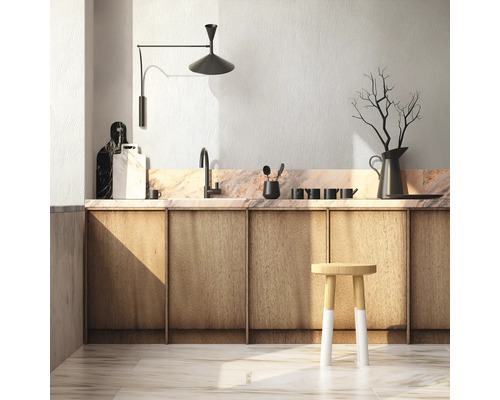 Scène de cuisine avec armoires en bois, plan de travail en marbre, évier, lampe et tabouret