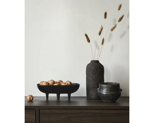 Dekoratives Arrangement mit einer Schale auf Füssen gefüllt mit Baumnüssen, einer Vase mit Trockenblumen und einem Topf.