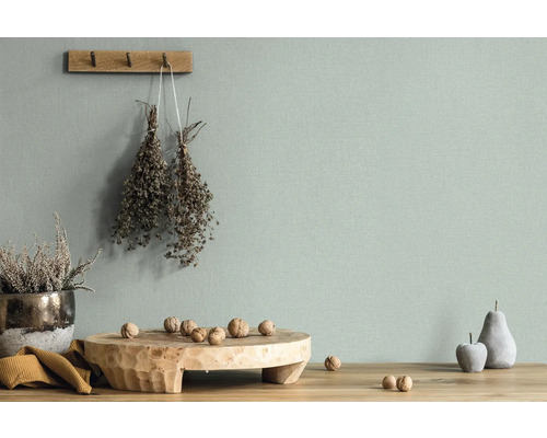 Dekorative Stillleben-Szene mit Holzelementen, Pflanzen und Accessoires vor einer Wand