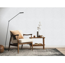 Wohnzimmer mit Sessel, Stehlampe, Teppich und Beistelltisch