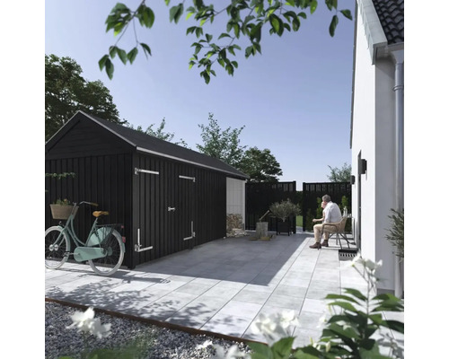 Scène de jardin avec remise à outils, terrasse et homme assis