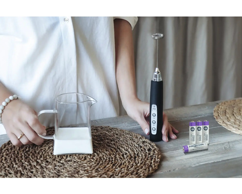 Mousseur à lait avec pot à lait et piles sur une table