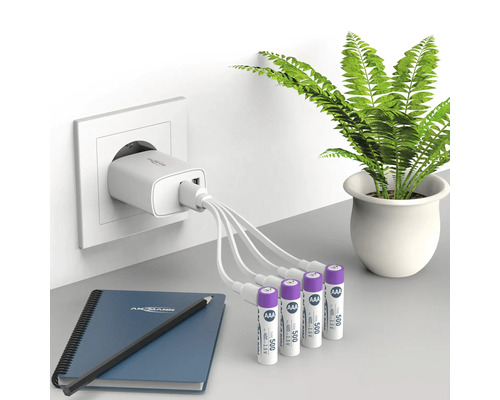 Chargeur avec plusieurs piles AAA, bloc-notes et stylo sur une table