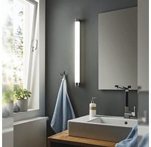 Salle de bains moderne avec lavabo, miroir et applique murale en forme de tube