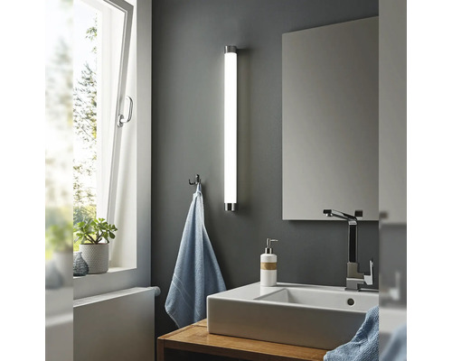 Salle de bains moderne avec lavabo, miroir et applique murale en forme de tube