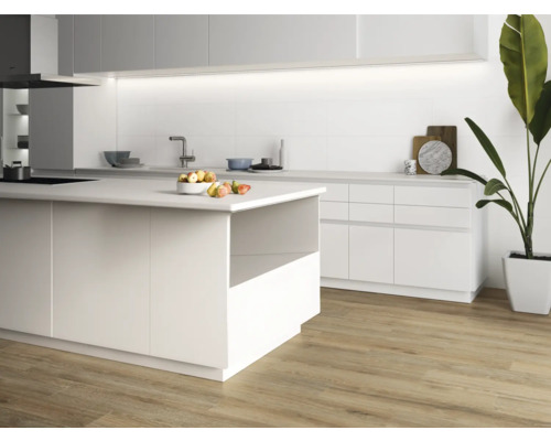 Cuisine claire avec îlot de cuisson, armoires blanches et plancher en bois