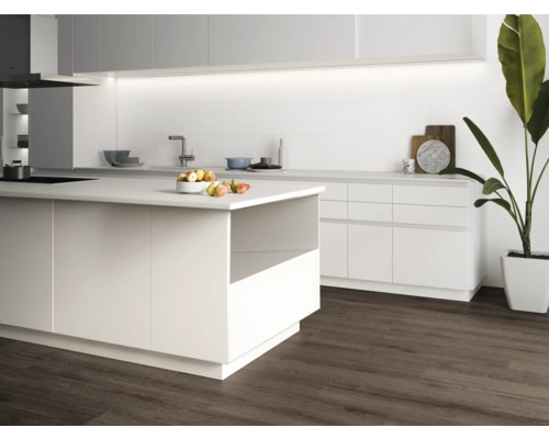 Cuisine claire avec îlot de cuisine, évier et parquet.