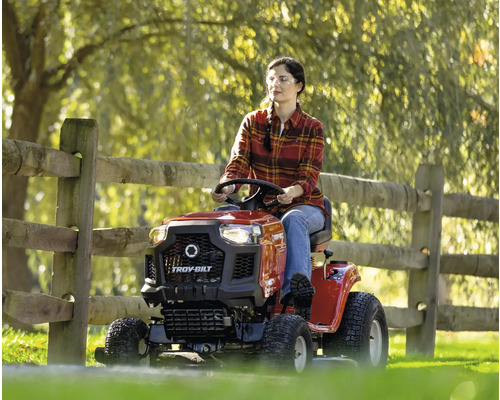 Femme conduisant une tondeuse autoportée Troy-Bilt dans le jardin