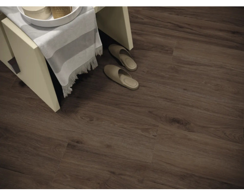 Photo d''intérieur d''une pièce avec un sol stratifié aspect bois, un petit tabouret et des chaussons.