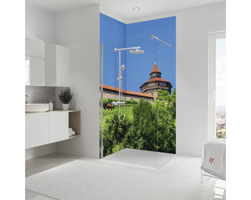 Salle de bain lumineuse avec douche, lavabo et décoration murale