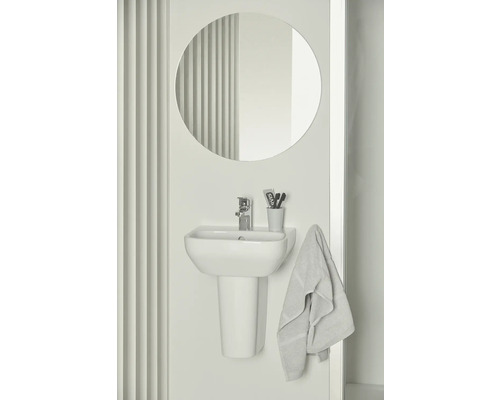 Badezimmer mit Aufsatzwaschbecken, Armatur, runder Spiegel und Handtuch