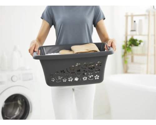 Femme tenant un panier à linge en plastique avec du linge