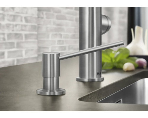 Spülmittelspender aus Edelstahl neben einem Spülbecken und Armatur