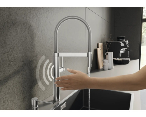 Robinet de cuisine en acier inoxydable avec commande tactile et douchette extractible dans une cuisine moderne.